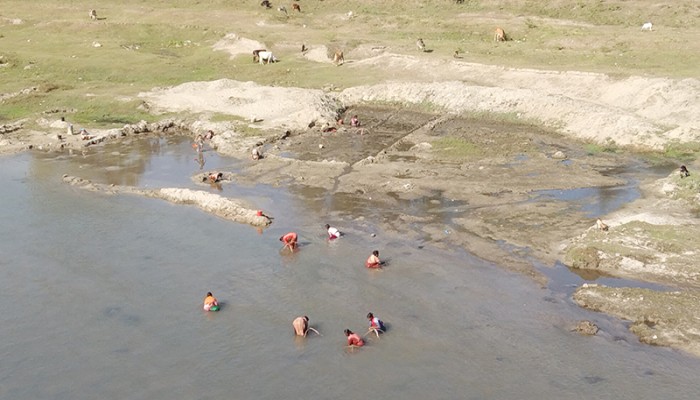 বরফগলা নদীতে নেমে পাথর তুলছেন পঞ্চগড়ের নারীরা